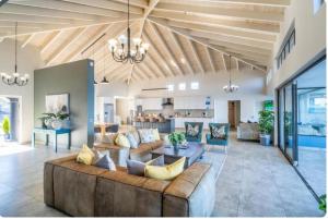 a large living room with a large couch and a kitchen at Breakwaters Haven - Luxury Villa Pezula in Knysna +9 photos
