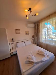 a white bed in a room with a window at LaRenta Sveti Vlas, ulitsa Cherno more 12 in Sveti Vlas +87 photos