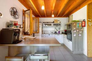 cocina con armarios blancos y techo de madera en L'edliane, en Font-Romeu-Odeillo-Via