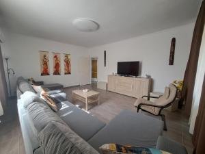 a living room with a couch and a tv at Napsugár apartman Balatonboglár in Balatonboglár +27 photos