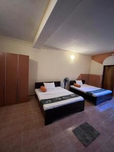 una camera con due letti e armadi di Sunbloom Hostel a Kandy