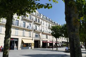 a large white building with balconies on a street at Disneyland Paris, appartement 70m², parking privé in Serris