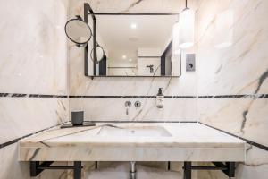 ein Badezimmer mit Waschbecken und Spiegel in der Unterkunft Descobertas Boutique Hotel by Aspasios in Porto