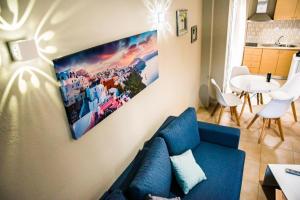 a living room with a blue couch and a table at DESIGN HOMe in Paleo Tsifliki