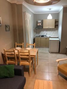 a living room with a table and chairs and a kitchen at DESIGN HOMe in Paleo Tsifliki
