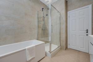 a bathroom with a shower and a bath tub at Watford Lodge - Air Host & Stay - A Home in the Heart of Anfield in Liverpool +42 photos