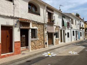 an empty street with buildings with flowers painted on them at Casa Trinidad in Denia