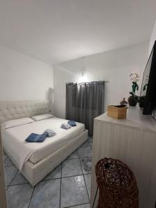 a small bedroom with a bed and a chair at Le pietre di Mario in Bari Sardo
