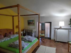 a bedroom with a canopy bed and a desk at LA CASA AL BREMBO b&b in Paladina