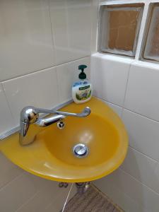 a yellow sink with a bottle of soap on it at LA CASA AL BREMBO b&b in Paladina