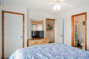 1 dormitorio con cama y vestidor con TV en Life Is Good, en Nags Head