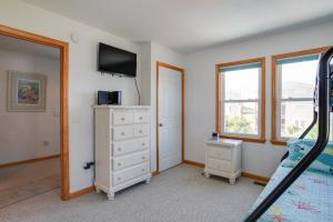 1 dormitorio con tocador y TV en la pared en Life Is Good, en Nags Head