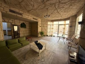 a living room with a green couch and a table at Desert Rose Villa 7 in Abu Dhabi