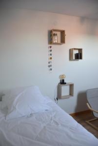 a bedroom with a white bed and a chair at La Petite Ferme d'Albert 