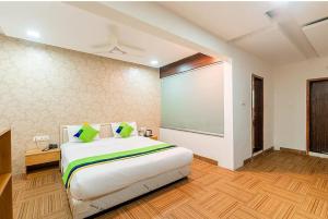プネにあるHotel Juglans Innのベッドルーム1室(大型ベッド1台、大画面スクリーン付)