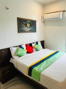 a bedroom with a bed with colorful pillows at Hotel I Stay in Bengaluru