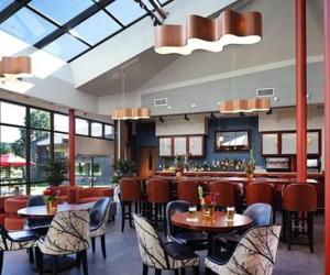 a restaurant with tables and chairs and a bar at Chauncey Hotel and Conference Center in Princeton