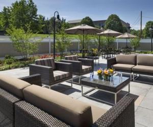 a patio with couches and a table with flowers on it at Chauncey Hotel and Conference Center in Princeton