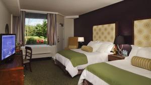 a hotel room with two beds and a flat screen tv at Chauncey Hotel and Conference Center in Princeton