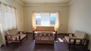a living room with two chairs and a couch at Green View Bungalow in Shillong +5 photos