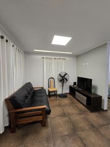 a living room with a black couch and a television at Aura Iguazú Apartment in Puerto Iguazú