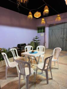 a white table and chairs and a table and a grill at Agréable maison près de la plage in Aglou