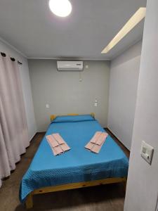 a room with a blue bed with two towels on it at Aura Iguazú Apartment in Puerto Iguazú