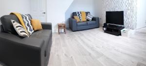 a living room with two couches and a television at Bright & Comfy 3-Bedroom Flat in Kexgill in Middlesbrough