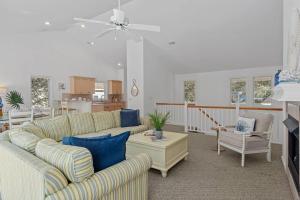 a living room with two couches and a table at Limoncello Grove Formerly Moondance in Corolla