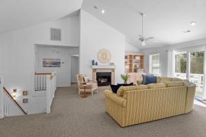 a living room with a couch and a fireplace at Limoncello Grove Formerly Moondance in Corolla