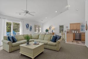 a living room with a couch and a table at Limoncello Grove Formerly Moondance in Corolla