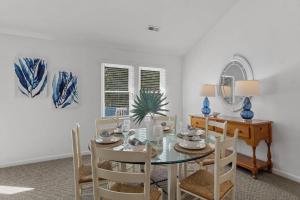 a dining room with a glass table and chairs at Limoncello Grove Formerly Moondance in Corolla +53 photos