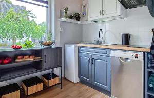 a small kitchen with blue cabinets and a sink at 3 Bedroom Awesome Home In Nowe Warpno in Nowe Warpno
