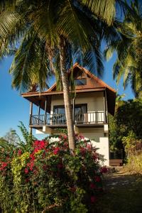 a house with a palm tree and flowers at Baan Talay in Salad Beach