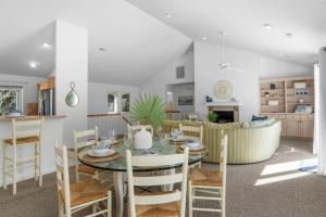 a dining room and living room with a table and chairs at Limoncello Grove Formerly Moondance in Corolla