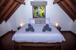 a bedroom with a bed with two pairs of slippers at Baan Talay in Salad Beach