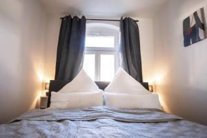 a bed with white pillows and a window at Auf dem Kassberg-Kanzler in Chemnitz