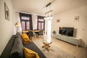 a living room with a couch and a tv and a table at Auf dem Kassberg-Kanzler in Chemnitz