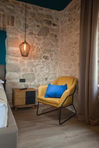 - une chambre avec une chaise jaune et un oreiller bleu dans l'établissement Villa Toni, à Tučepi