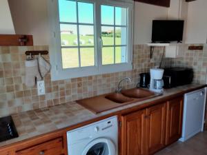 a kitchen with a sink and a washing machine at Etxe ttikia in Ahetze