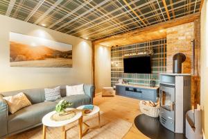 a living room with a couch and a tv at Ferienhaus Altstadtchalet in Schmallenberg