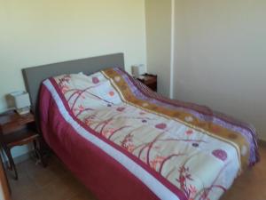 a bed with a red and white blanket on it at Etxe ttikia in Ahetze
