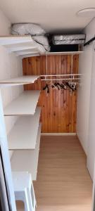 un dressing avec des murs en bois et des étagères blanches dans l'établissement Appartement au pied des pistes, à Albiez-Montrond