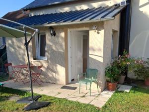 un patio con una sedia verde e una porta di Maison à Gimel les Cascades en Corrèze a La Bitarelle