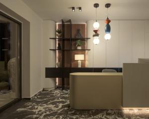 a lobby with a reception desk and pendant lights at Allegro Suites in Rethymno