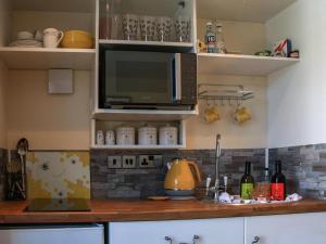 a kitchen with a microwave and a counter top at The Beehive in Mundesley