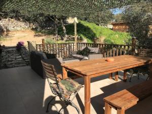 a wooden table and chairs on a patio at La Villa Maquis in Bonifacio