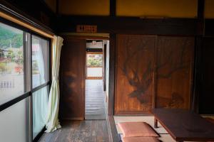 a room with a door and a table and a window at THE Aramaki 日本の魅力と伝統が詰まった築200年の古民家 1日1組限定貸切 in Ō-naka