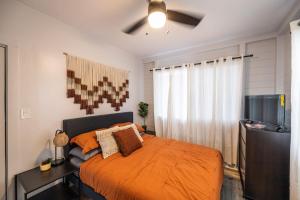 une chambre avec un lit et une télévision à écran plat dans l'établissement Tropical Haven - 2BR Hilo, à Hilo