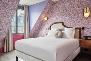 a bedroom with a large white bed with purple walls at Hôtel Joséphine & SPA by HappyCulture in Paris